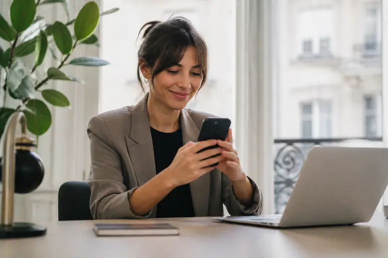 Jeune femme interagissant avec son smartphone pour l'assurance-auto-qlara.