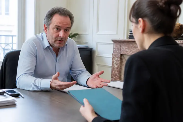 Employée remettant un dossier à un patron peu coopératif, solde de tout compte retardé
