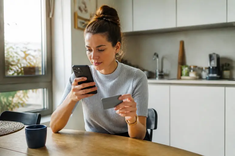 Une femme utilise ses chèques Cadhoc en ligne, explorant les options d'achat depuis son domicile.