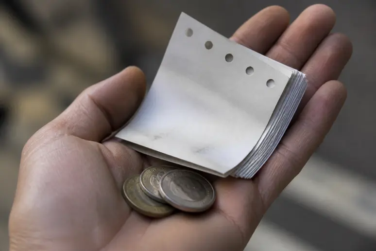 Mains tenant des pièces de monnaie et des pages de calendrier, symbolisant la conversion de temps en argent.