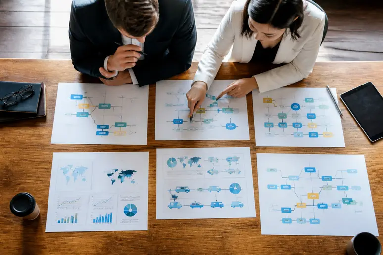 Professionnels analysant des schémas de flux et des options d'agrégation sur une table de réunion