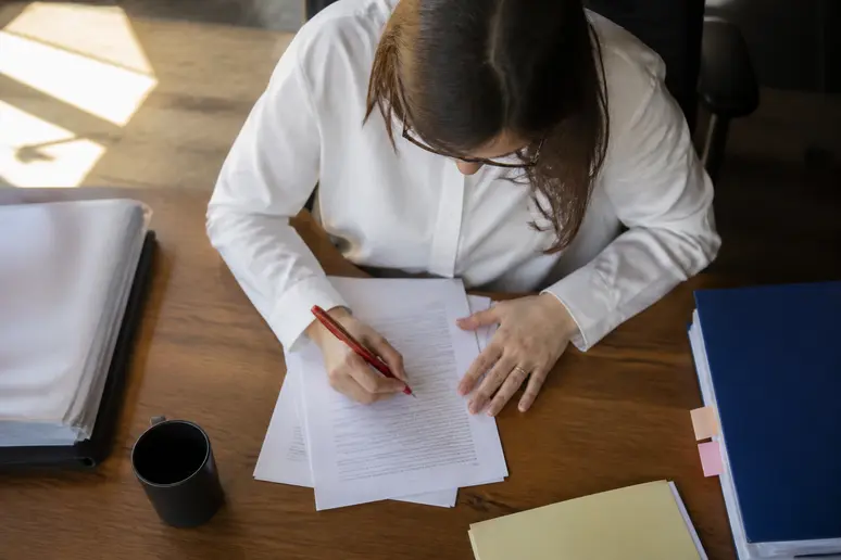 Relecture attentive d'un dossier professionnel pour traquer les erreurs de rédaction avant validation.