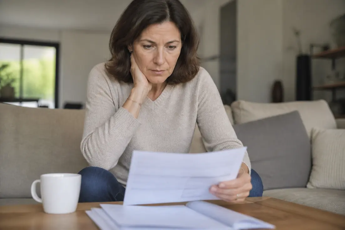 Une femme française consulte son relevé bancaire, intriguée par le virement impots 645 euros.
