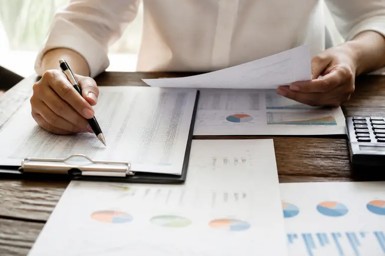 Analyste examinant un grand livre comptable pour ventiler les charges fixes et variables