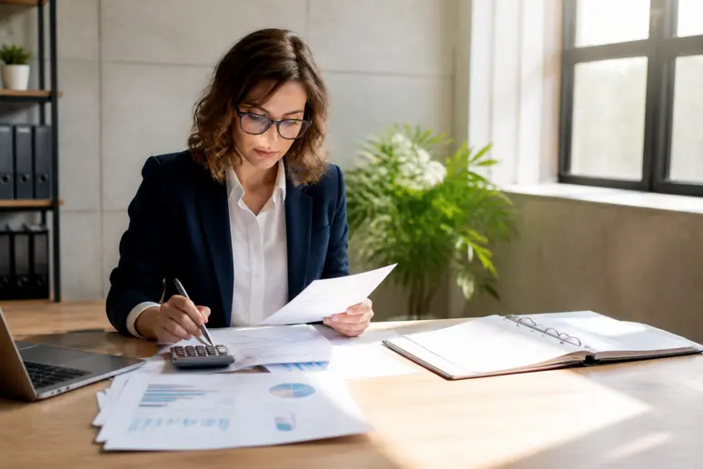 Gestionnaire consultant des documents financiers et un calendrier sur son lieu de travail.