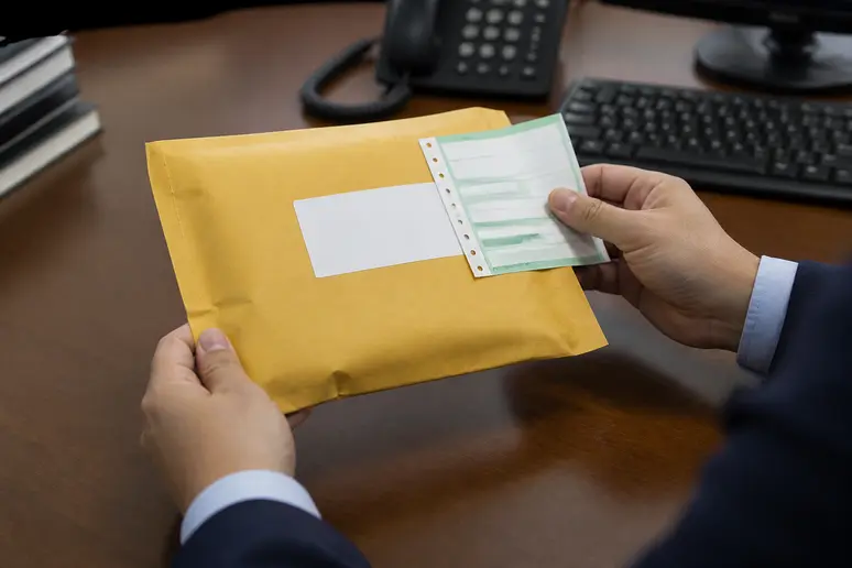 Personne tenant une lettre recommandée avec accusé de réception avant une mise en demeure pour impayé.