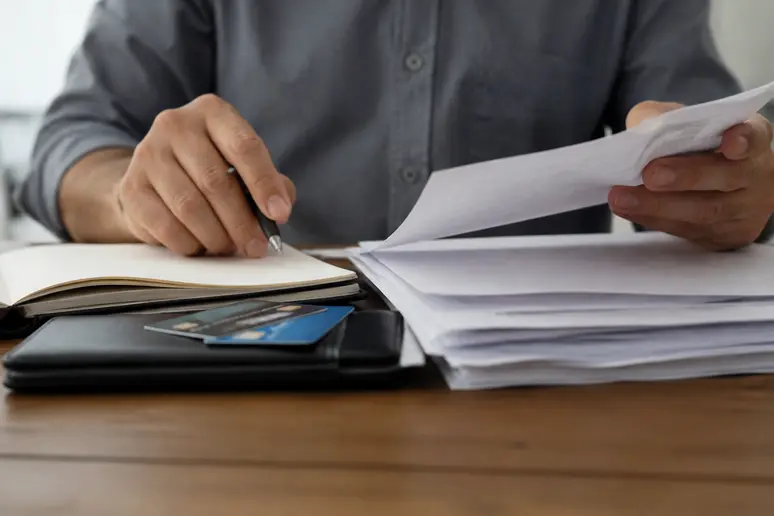 Mains consultant des identifiants de connexion et des documents administratifs lors d'un diagnostic technique